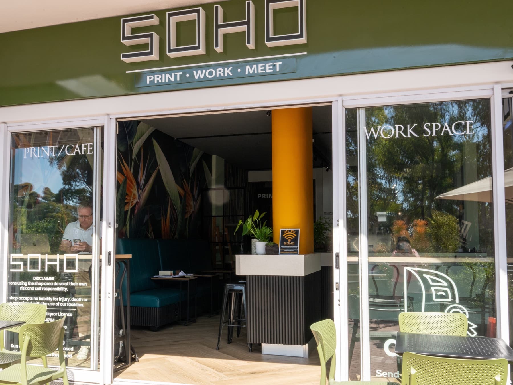 The SOHO shopfront on Main Road, its green fascia reading Print · Work · Meet, with the folding doors open onto the café and work space.